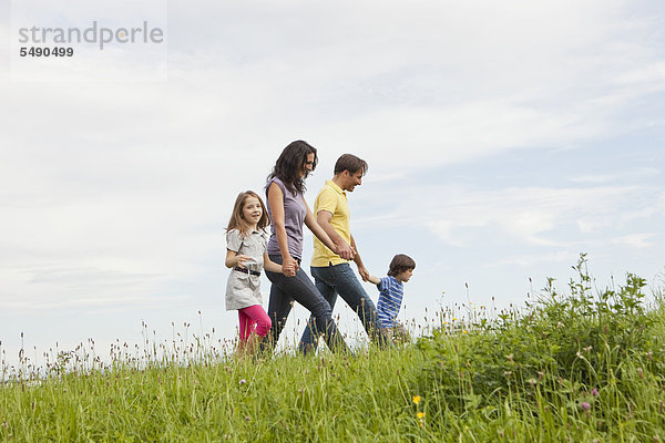 Deutschland  Bayern  Familie beim Graswandern im Park