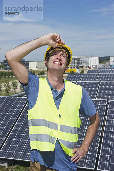 Deutschland  München  Techniker in Solaranlage  lächelnd