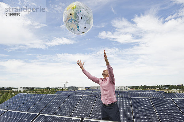 Reifer Mann mit Globus in Solaranlage