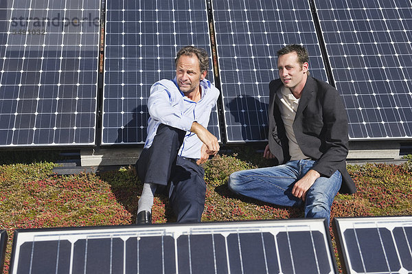 Zwei Mann sitzen und entspannen in einer Solaranlage