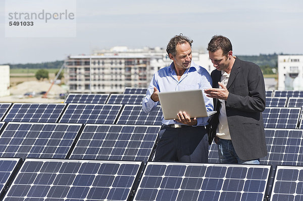 Ingenieur und Mann diskutieren in der Solaranlage