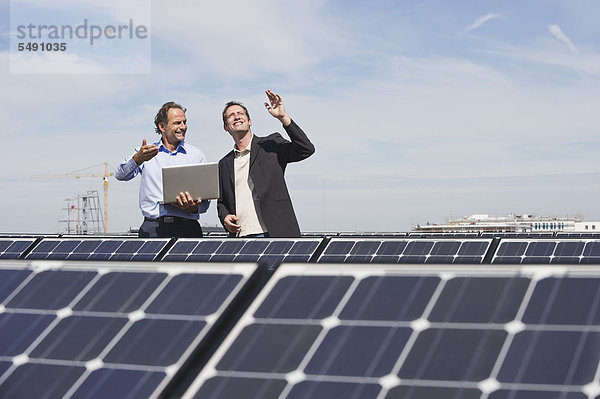 Ingenieur und Mann diskutieren in der Solaranlage