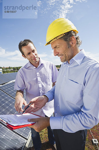 Mann im Gespräch mit Ingenieur in der Solaranlage