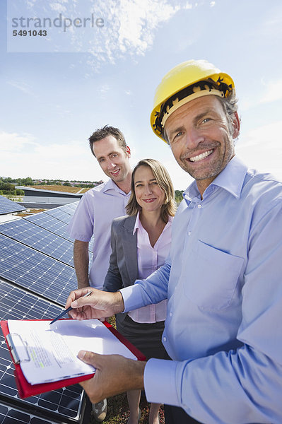 Ingenieur mit Mann und Frau in Solaranlage  lächelnd  Portrait