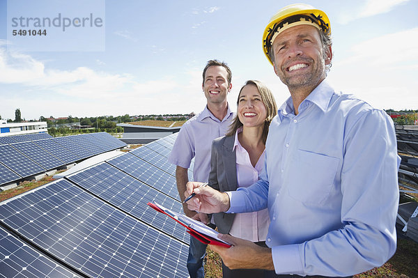 Ingenieur mit Mann und Frau in Solaranlage  lächelnd