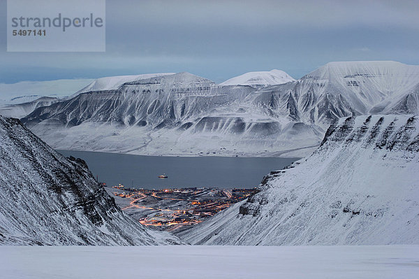 Zwischen hohen Bergen liegt die Stadt Longyearbyen im Dämmerlicht am Adventfjorden  Spitzbergen  Svalbard  Norwegen  Europa