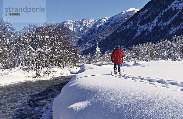 Mann geht durch frisch gefallenen Schnee  Sylvenstein  Oberbayern  Deutschland  Europa