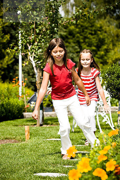 Zwei Mädchen spielen im Garten