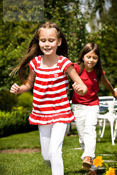 Zwei Mädchen spielen im Garten