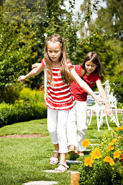 Zwei Mädchen spielen im Garten