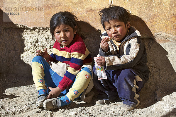 Kekse essende Quechua-Kinder in Quetena Chico  Atacama-Wüste  Altiplano  südliches Bolivien  Südamerika