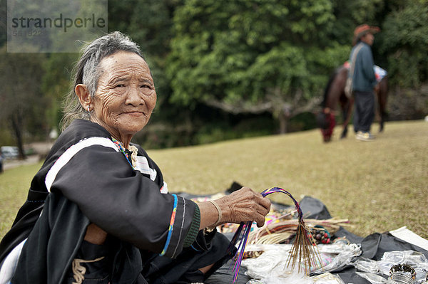 Alte Frau aus einem Bergstamm verkauft Souvenirs an einem königlichen Projekt in Norden von Thailand  Asien