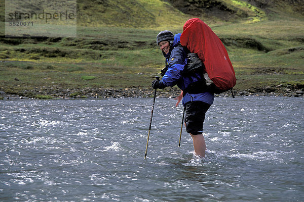 Frau mit Rucksack furtet Fluss  ¡lftavatn  Laugavegur Wanderweg  Naturschutzgebiet Fjallabak  Hochland  Island  Europa