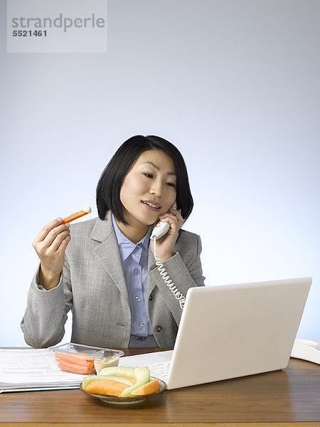 Geschäftsfrau  Schreibtisch  arbeiten  essen  essend  isst