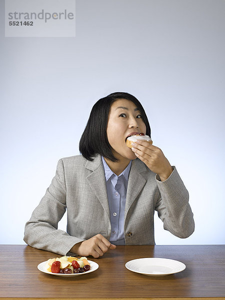 Geschäftsfrau  Schreibtisch  Donut  essen  essend  isst