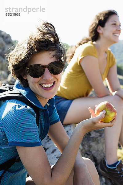 Frau isst Apfel im Freien