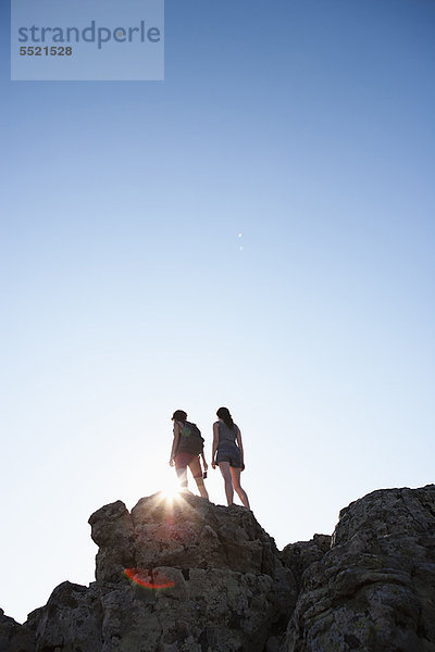 Silhouette der auf Felsen stehenden Wanderer