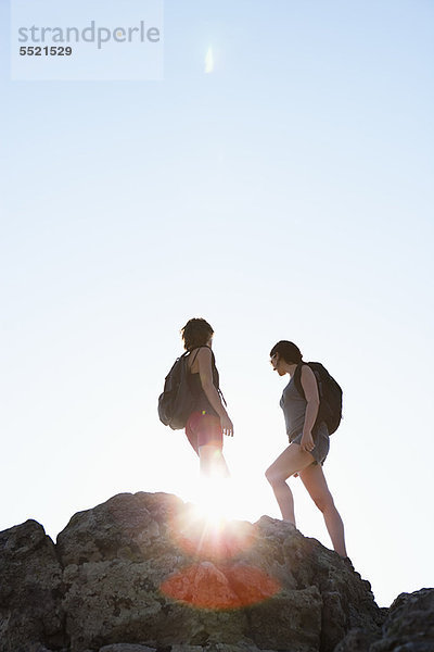 Silhouette der auf Felsen stehenden Wanderer