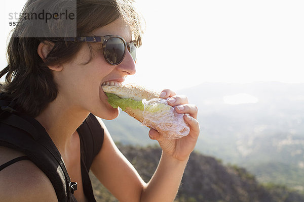 Frau isst Sandwich im Freien