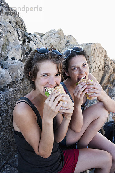 Wanderer essen Sandwiches auf Felsen