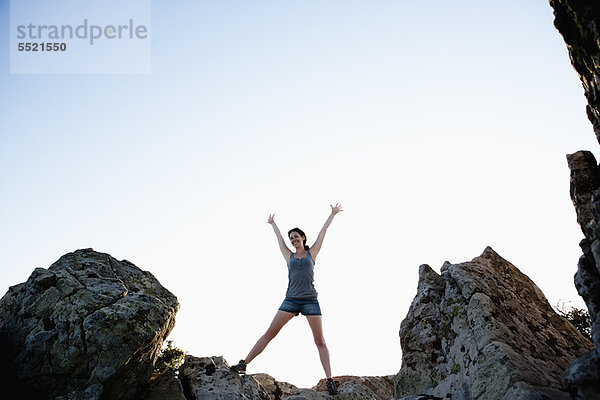 Frau jubelt auf Felsen