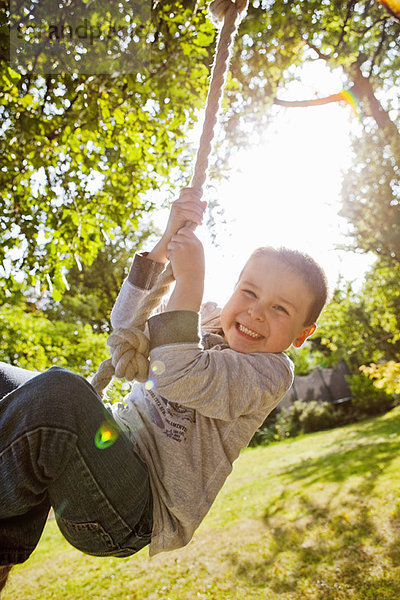 Junge spielt auf Seilschaukel im Hinterhof