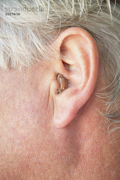 Nahaufnahme des Hörgerätes einer älteren Person