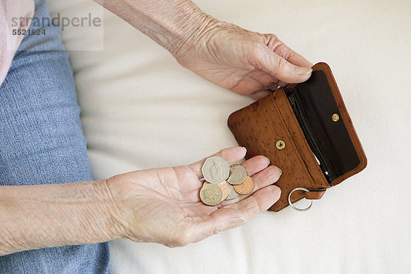 Nahaufnahme einer älteren Frau beim Zählen von Münzen