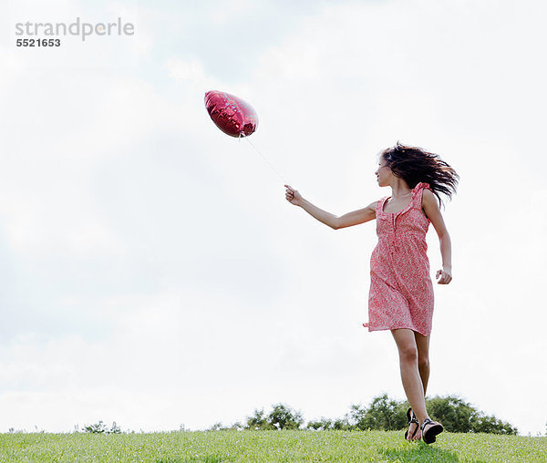 Teenager mit herzförmigem Ballon