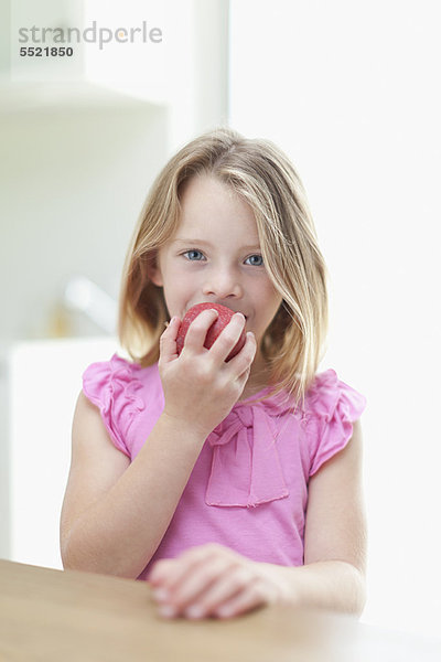 Mädchen essen Apfel in der Küche