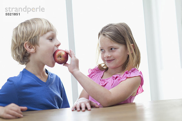 Kinder essen Apfel in der Küche