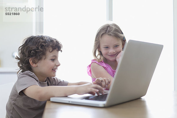 Lächelnde Kinder mit dem Laptop zusammen