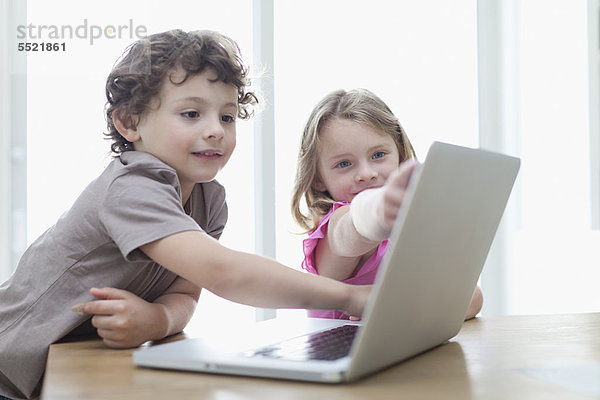 Lächelnde Kinder mit dem Laptop zusammen