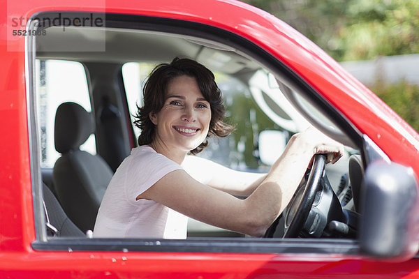 Frau lächelt im Fahrersitz des Autos