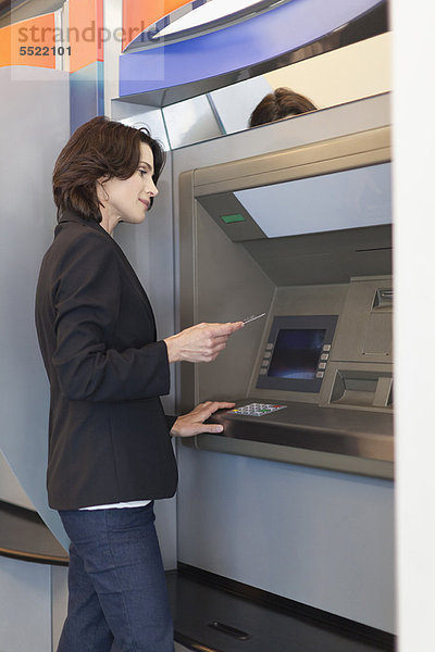 Geschäftsfrau mit ATM im Freien