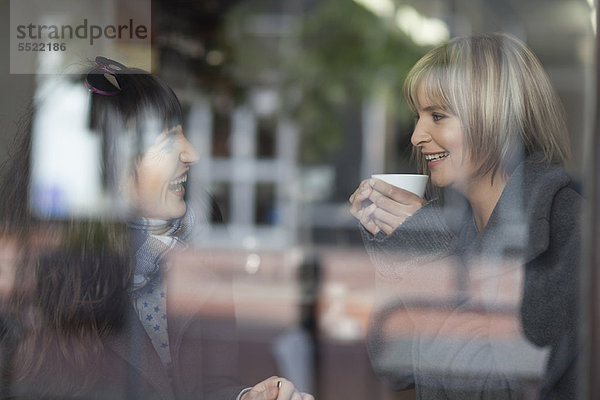 Lächelnde Frauen beim Kaffee im Café