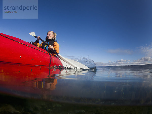 Frau beim Kajakfahren im stillen See