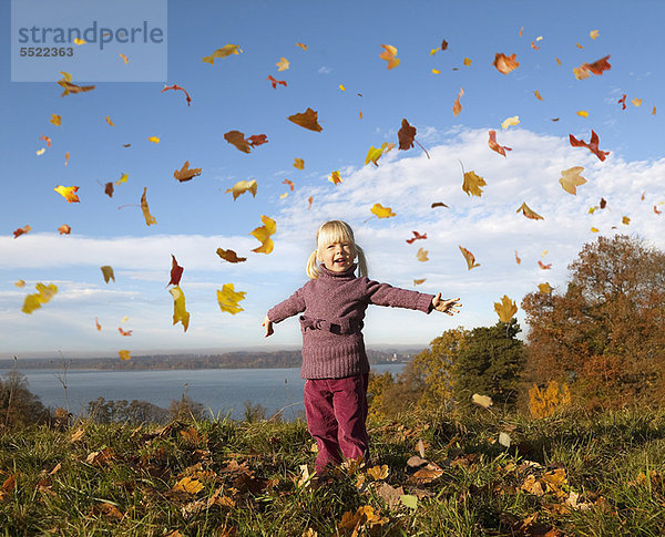 Mädchen spielt im Herbstlaub