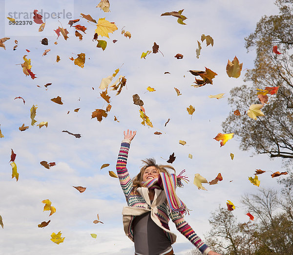 Frau spielt im Herbstlaub