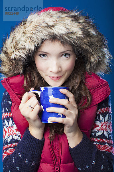 Frau in Parka trinkt Kaffee