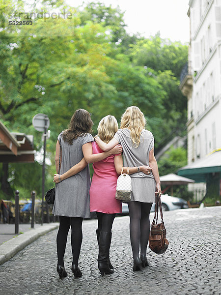 Frauen  die auf der Kopfsteinpflasterstraße laufen.