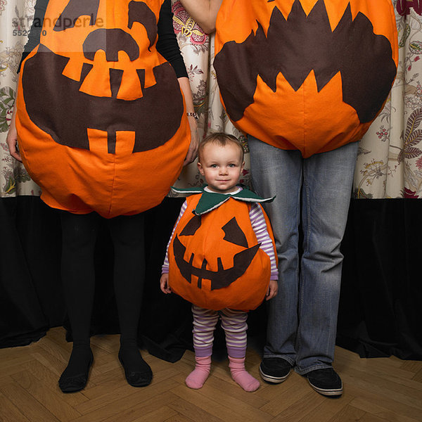 Familie verkleidet als Kürbisse zu Halloween