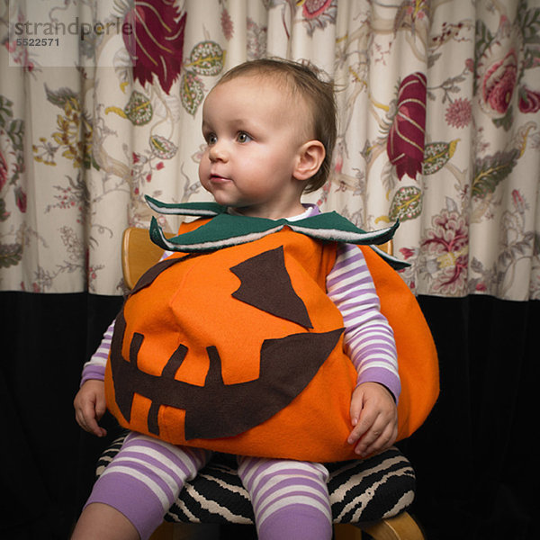 Kind als Kürbis verkleidet für Halloween