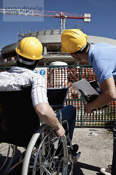 Mann im Rollstuhl auf der Baustelle