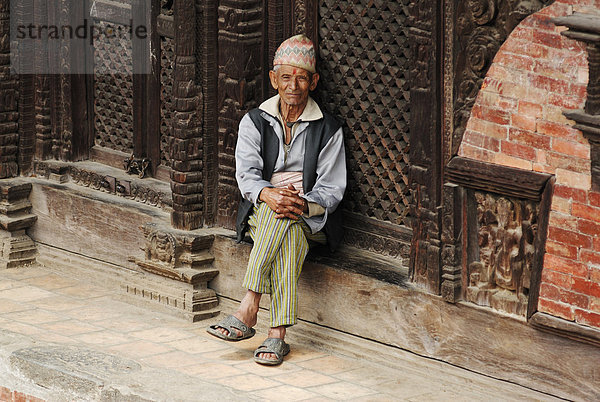 Sitzender Mann mit Kopfbedeckung  Durbar Square  Bhaktapur  Kathmandu Tal  Nepal  Asien