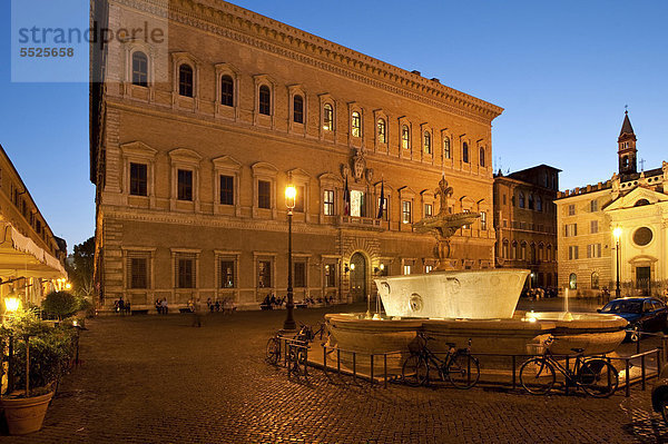 Der Palazzo Farnese mit einem der Granitbecken auf der Piazza Farnese aus dem Frigidarium von Caracalla  die jetzt als Brunnen dienen  in der Abenddämmerung  Rom  Italien  Europa