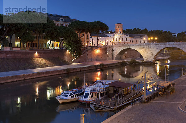 Der Fluss Tiber  die Tiberinsel und die Ponte Cestio in der Abenddämmerung mit Ausflugsbooten  Rom  Italien  Europa