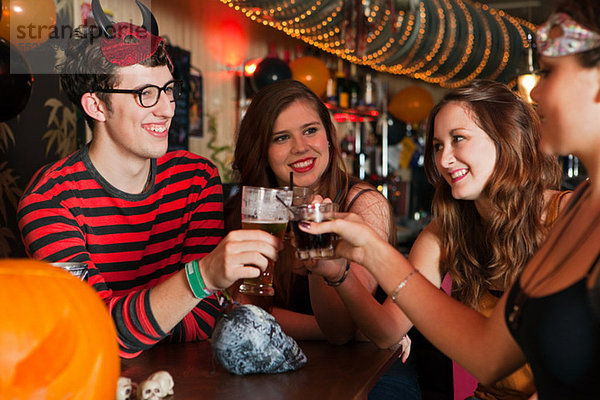 Junge Freunde toasten Getränke in der Bar