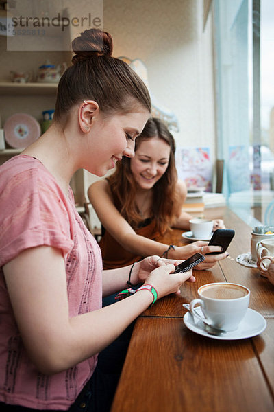 Junge Frauen im Café mit Handys