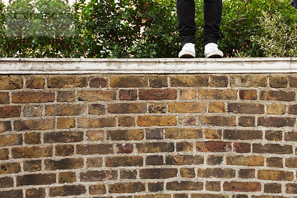 Frau in Jeans auf der Wand stehend  niedriger Schnitt